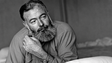 Retrato en blanco y negro del escritor estadounidense Ernest Hemingway apoyando la mano en su cuello en Cuba.