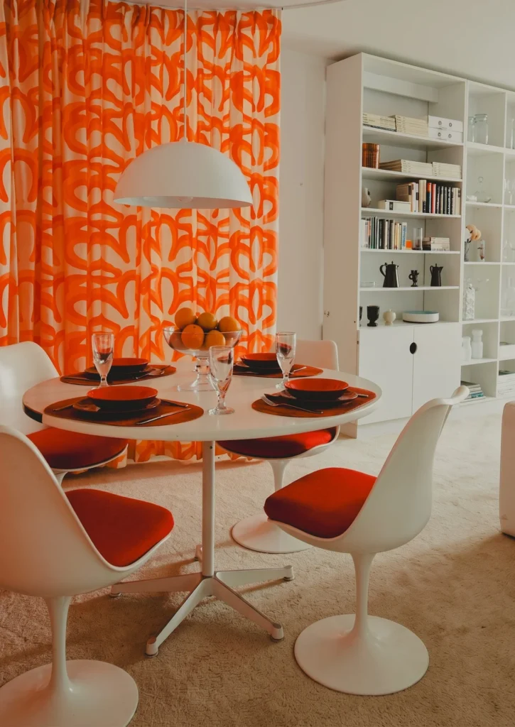Comedor con mesa y sillas Tulip de Eero Saarinen, destacando el diseño de pedestal único en aluminio y fibra de vidrio para resolver la congestión visual.