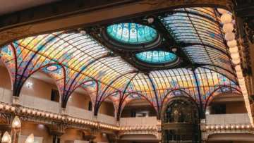 Vista panorámica del vitral Tiffany en el Gran Hotel de la Ciudad de México, resaltando la ingeniería de hierro y cristal de la Belle Époque tropicalizada.