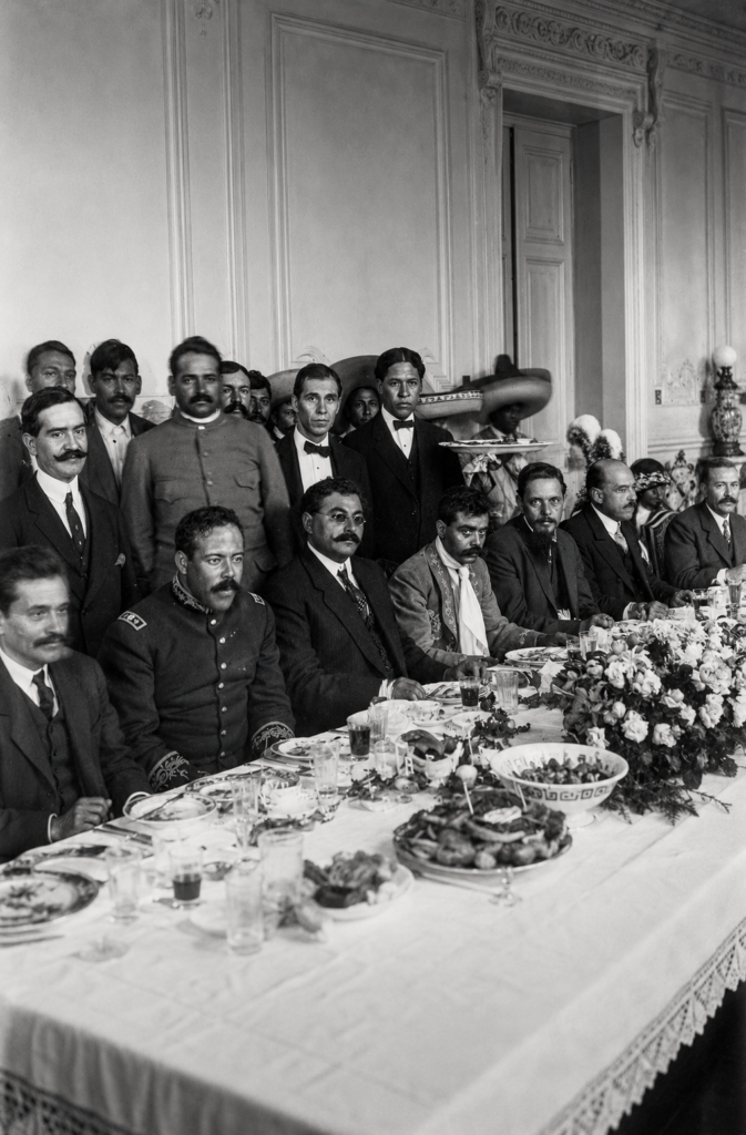 Fotografía histórica del banquete en Palacio Nacional en 1914 con Pancho Villa, Emiliano Zapata y Eulalio Gutiérrez. Archivo Casasola del INAH, ideal para ilustrar poemas y corridos de la Revolución Mexicana.