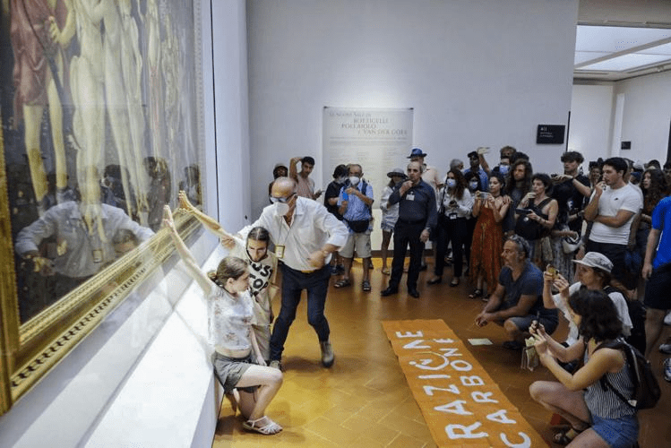 Momento donde activistas ecológicos de Ultima Generazione pegan sus manos al cuadro de Botticelli