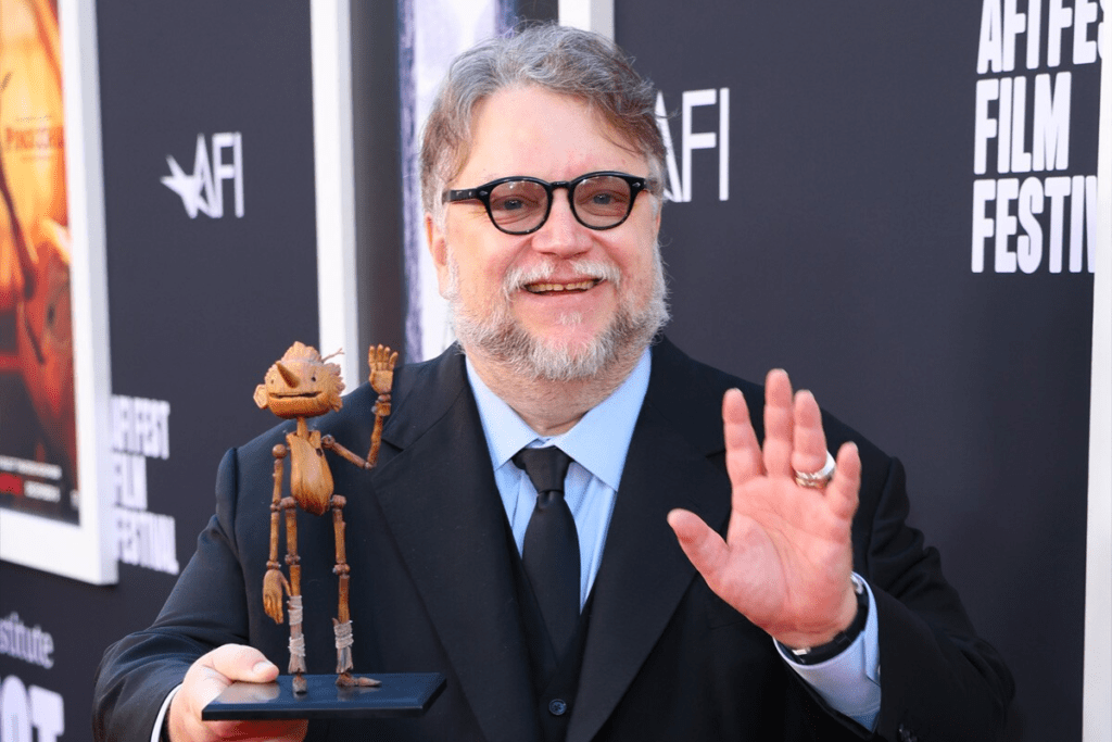 Guillermo del Toro sosteniendo una figura de Pinocchio, el personaje principal de su más recente filme