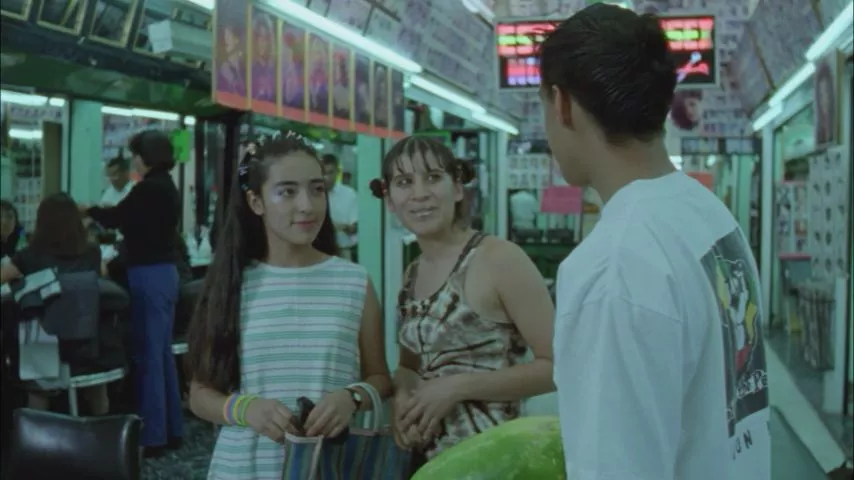Fotograma de la película mexicana 'Perfume de violetas (nadie te oye)' (2001) de Maryse Sistach, donde las actrices Ximena Ayala y Nancy Gutiérrez interpretan a las adolescentes Yessica y Miriam dentro de una estética estética urbana de peluquería en la Ciudad de México.