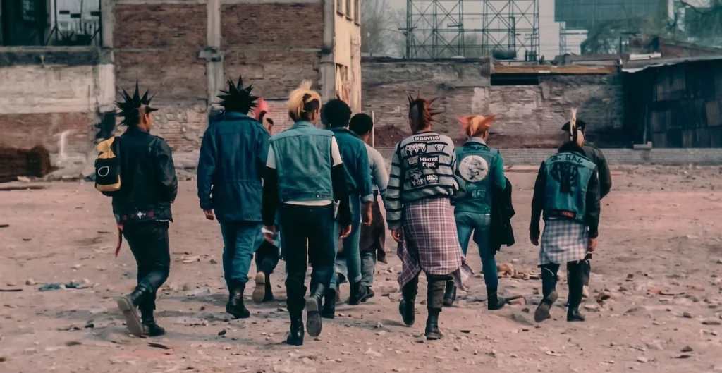 Grupo de jóvenes punks caminando por una zona industrial en México, mostrando crestas, estoperoles y parches como símbolo de resistencia y contracultura urbana.