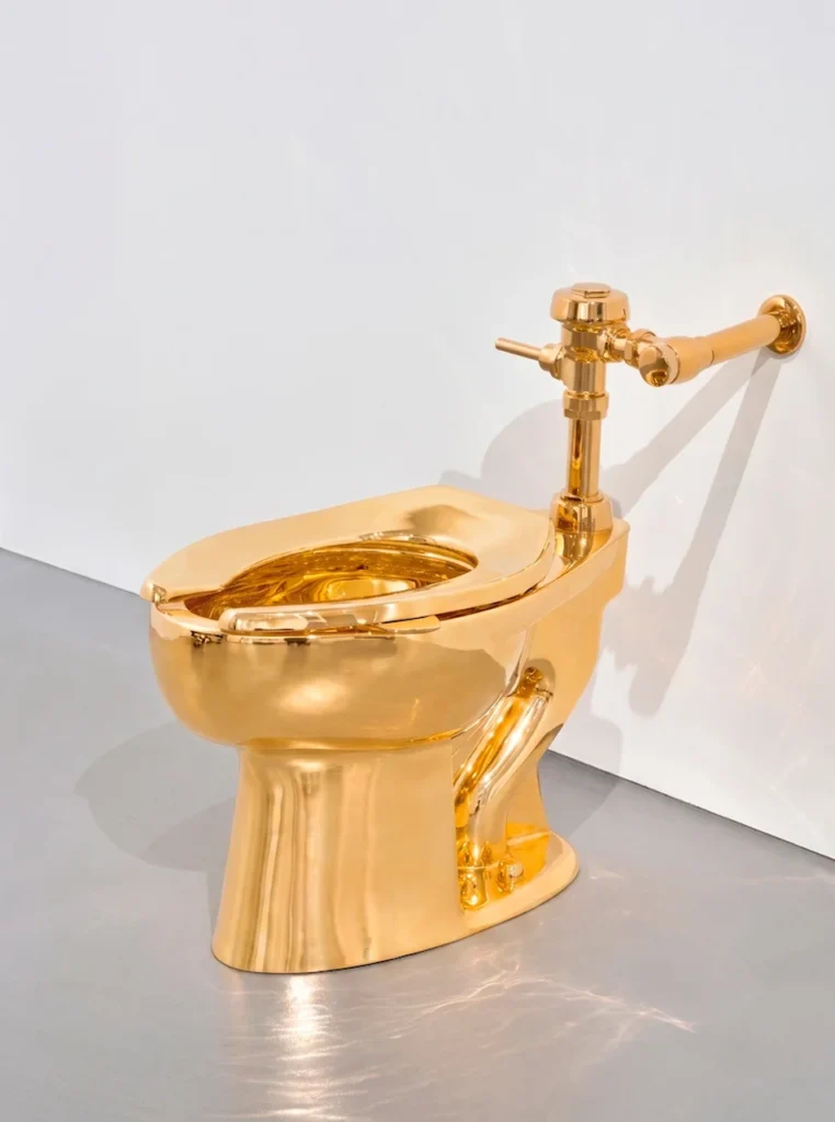 Escultura de un inodoro completamente funcional fabricado en oro de 18 quilates, correspondiente a la obra America de Maurizio Cattelan.