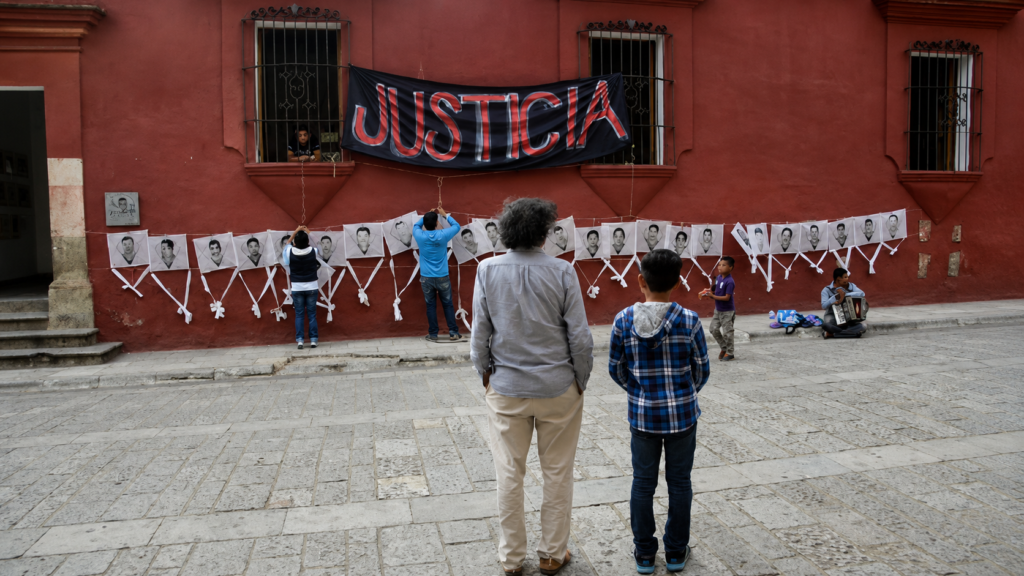 El maestro Francisco Toledo junto a un niño sosteniendo papalotes con los rostros de los 43 estudiantes desaparecidos de Ayotzinapa en Oaxaca.