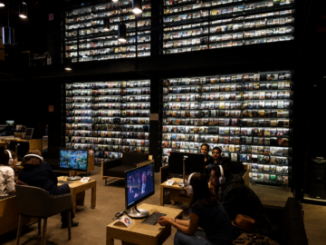 Cómo puedo sacar una cita para entrar a la Videoteca Digital Carlos Monsivaís Usuarios sentados frente a computadoras de consulta en el interior de la Videoteca Digital Carlos Monsiváis de la Cineteca Nacional de México, con enormes estanterías repletas de películas en formato físico de fondo.