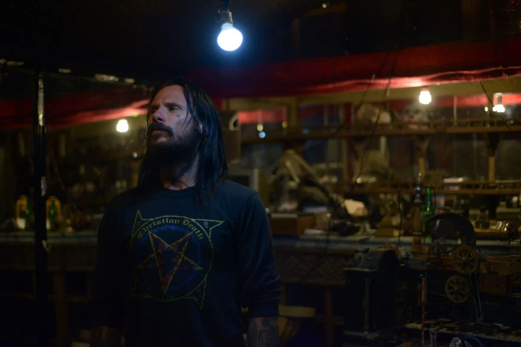 El músico Edwin Borsheim con una playera de la banda Christian Death en una escena en interiores del documental Dead Hands Dig Deep de Kettle Cadaver.
