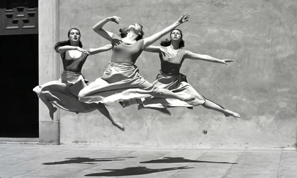 Fotografía de estudio de Imogen Cunningham capturando tres bailarinas de danza moderna en un salto sincronizado, destacando la nitidez, volumen y control formal del Grupo f/64.