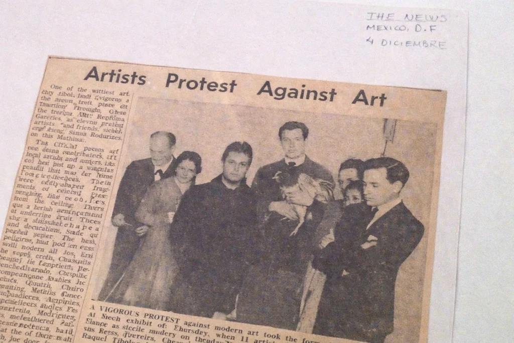 Recorte de prensa original de 1961 del diario The News con el titular "Artists Protest Against Art", mostrando a Pedro Friedeberg y al grupo Los Hartos en una manifestación contra el arte moderno.