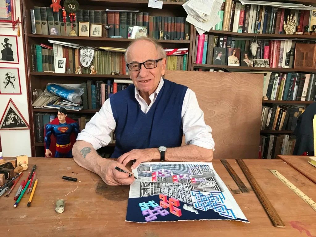 Pedro Friedeberg en su estudio de trabajo, rodeado de libros y terminando una obra gráfica policromática