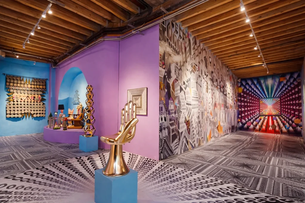 Vista panorámica de una instalación de Pedro Friedeberg con muros de cubos cromáticos y patrones geométricos en blanco y negro.