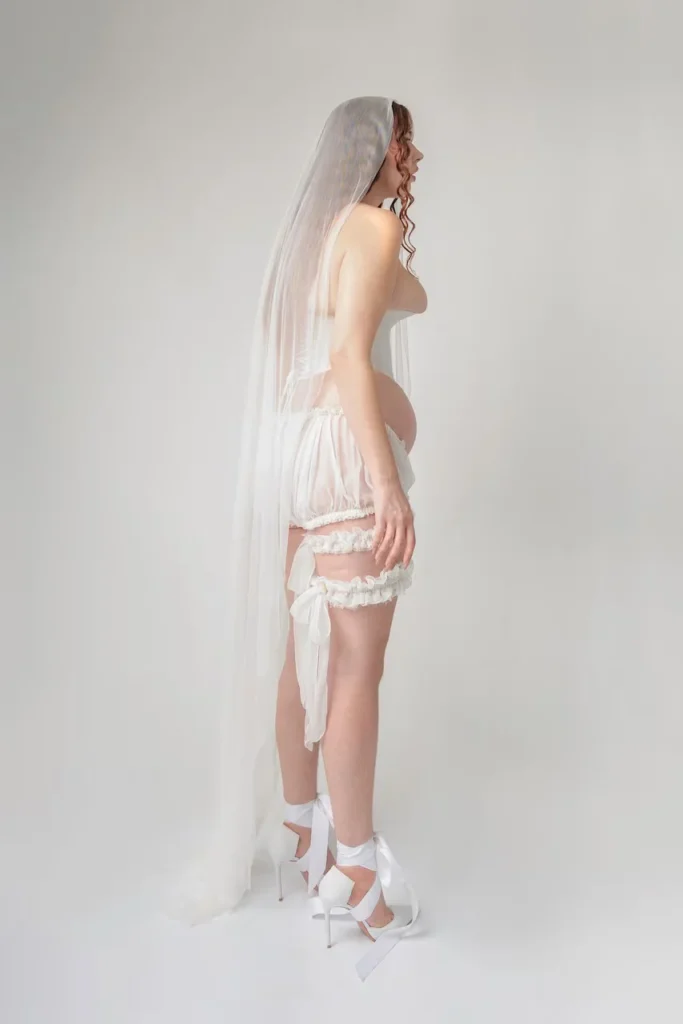 Fotografía de perfil de Michaela Stark mostrando la presión del corsé sobre la silueta y el volumen natural del cuerpo, técnica de alta costura conceptual.