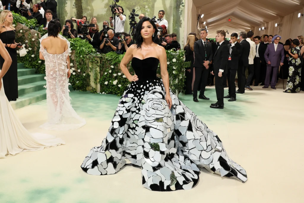 Lauren Sánchez posando en la Met Gala con un vestido negro de escote corazón y falda con diseño de pétalos en blanco y negro.