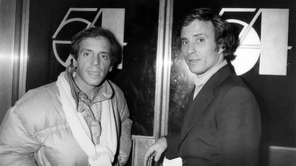 Los fundadores de Studio 54, Steve Rubell e Ian Schrager, posando frente a las puertas con el logotipo del club en Nueva York, 1978.