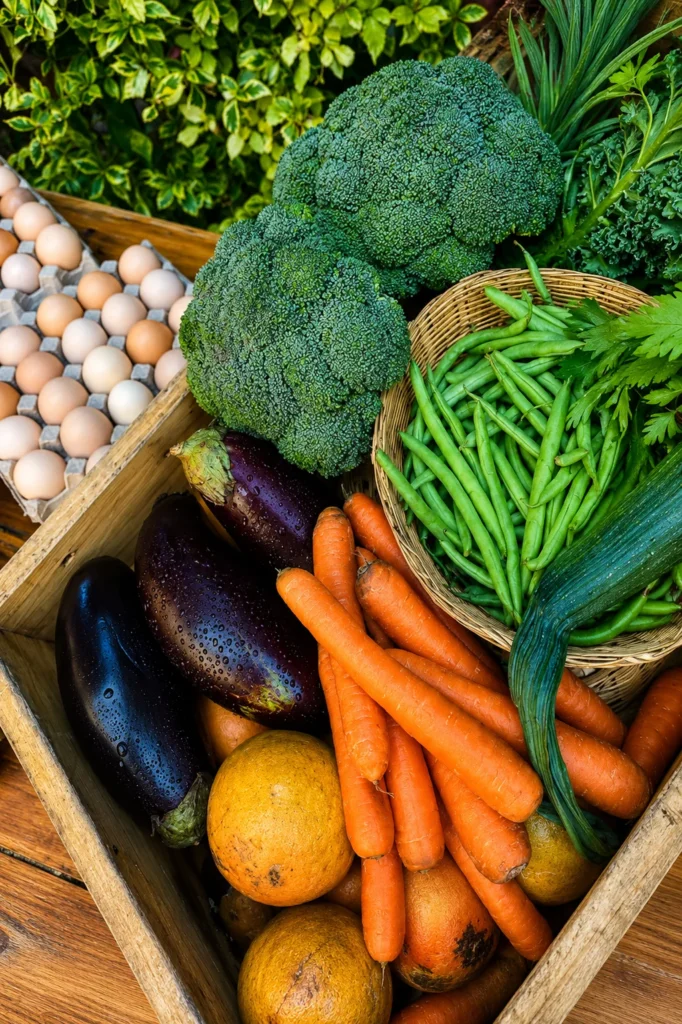 Canasta con verduras frescas, brócoli, zanahorias, berenjenas y huevos de rancho en un mercado agroecológico de la CDMX.