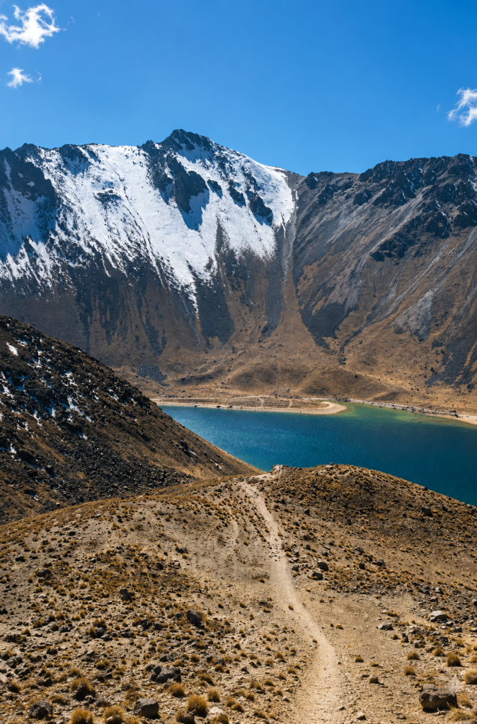 Vista en picada de un sendero de tierra que desciende hacia la Laguna del Sol en el cráter nevado del volcán Nevado de Toluca, México.