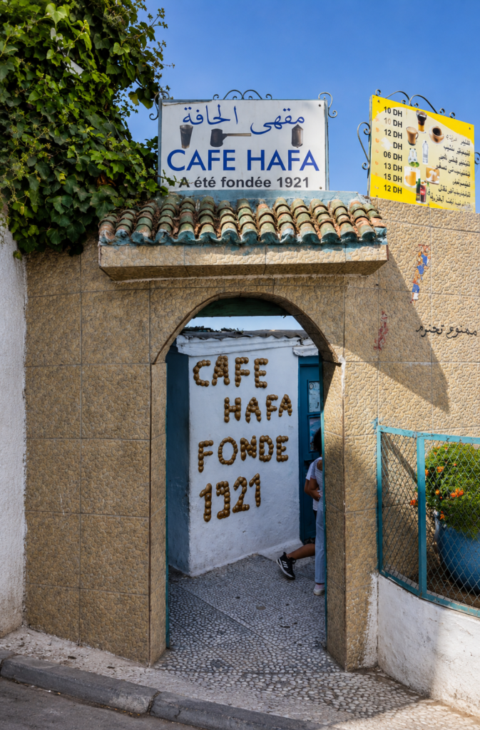 Entrada principal con arco del histórico Café Hafa en Tánger, Marruecos, mostrando el letrero que indica su fundación en 1921, lugar frecuentado por el escritor Paul Bowles.