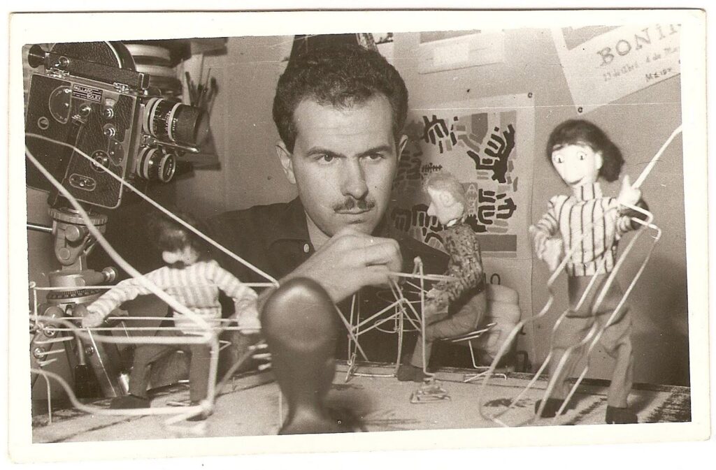 El director argentino Carlos González Groppa ajustando los alambres de las marionetas de madera en el set de filmación de la película mexicana de stop motion La Odisea de los Muñecos en la década de 1970.