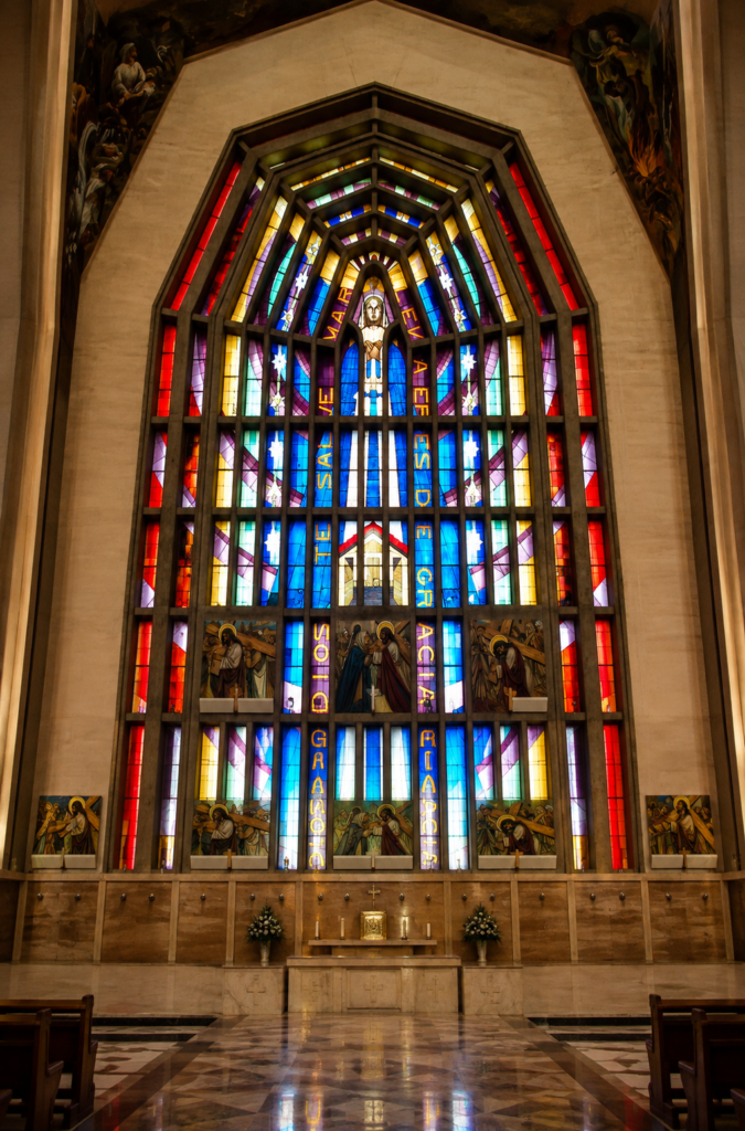 Detalle de gran vitral neogótico moderno con la inscripción Dios te salve María llena eres de gracia en la Parroquia del Purísimo Corazón de María CDMX.