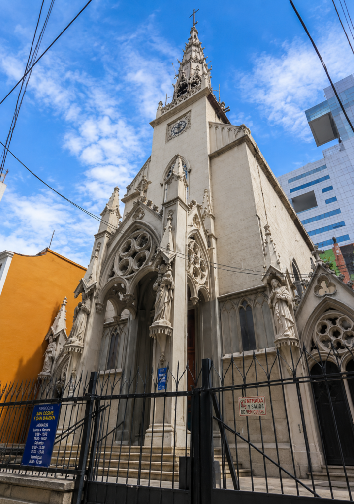 Fachada de estilo neogótico germánico de la Parroquia del Santo Niño de la Paz en la Colonia Juárez, Ciudad de México. Muestra arcos apuntados, estatuas de piedra y una torre con aguja calada frente a un cielo con nubes.