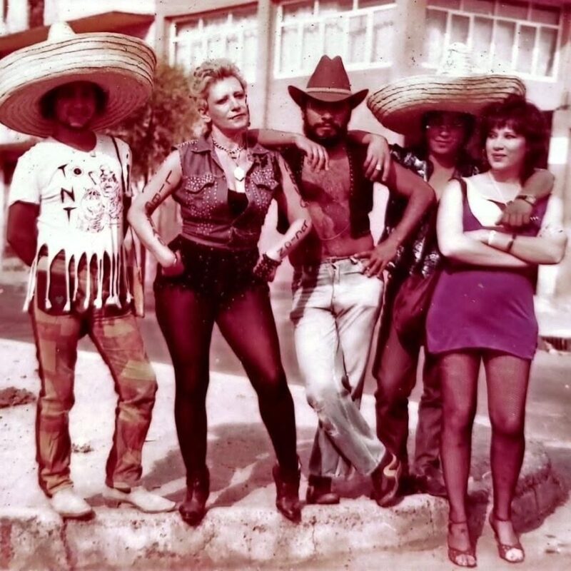 Texto alternativo: Integrantes de T.N.T., banda del punk y rock underground mexicano, posan en una calle durante los años ochenta.
