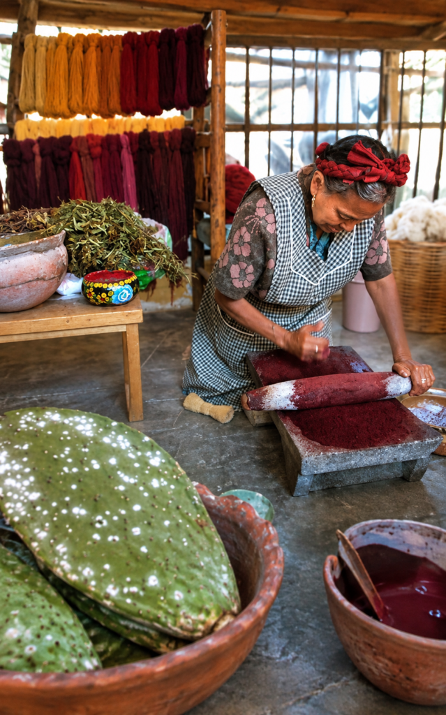 Luvia Aurora Bazán Ruiz muele grana cochinilla en un metate para obtener pigmento rojo en Teotitlán del Valle.