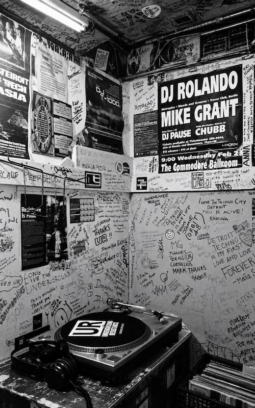 Tornamesa de Underground Resistance frente a paredes cubiertas de firmas, flyers y mensajes en Submerge, Detroit.
