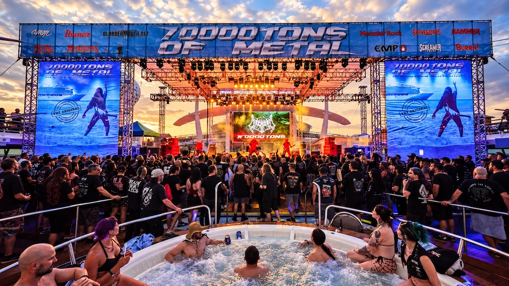 Concierto de 70000 TONS OF METAL al atardecer, con público frente al escenario y asistentes en un jacuzzi de la cubierta del crucero.