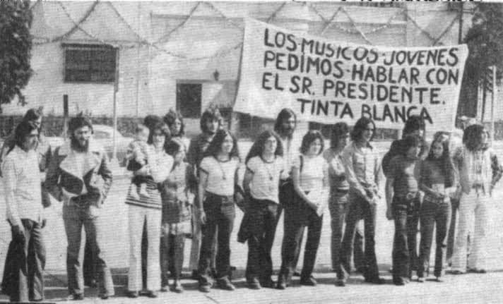 Jóvenes junto a una manta de Tinta Blanca que solicita hablar con el presidente, durante una protesta de músicos de rock.