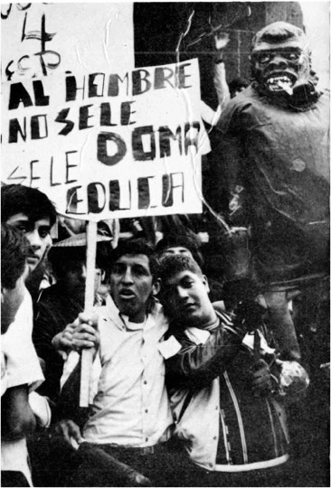 Jóvenes en una manifestación con una pancarta y una figura de gorila, en una fotografía histórica en blanco y negro.